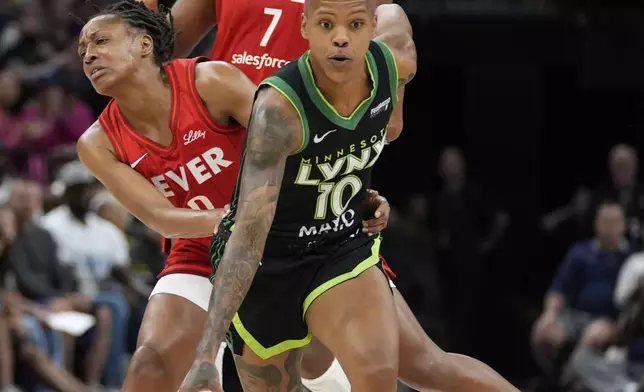 Minnesota Lynx guard Courtney Williams (10), front, is fouled by Indiana Fever guard Kelsey Mitchell (0), middle, during the first half of a WNBA basketball game Sunday, Aug. 24, 2025, in Minneapolis. (AP Photo/Abbie Parr)