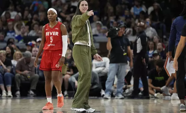Indiana Fever guard Caitlin Clark (22), middle, points during the second half of a WNBA basketball game against the Minnesota Lynx, Sunday, Aug. 24, 2025, in Minneapolis. (AP Photo/Abbie Parr)