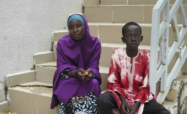 Israel Peter, who fled his village following an attack by Boko Haram Islamic extremists, right and Ramatu Usman, a student who was dropped from the school, pose for a photo, at the Future Prowess Islamic Foundation School, in Maiduguri, Nigeria, Thursday, July 24, 2025. (AP Photo/Sunday Alamba)