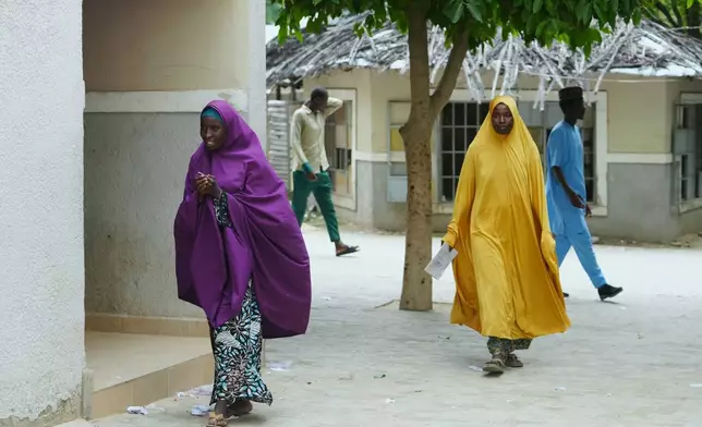 Ramatu Usman, a student who was dropped by the school, left and her mother Hajara Musa, walk past the school of Future Prowess Islamic Foundation, in Maiduguri, Nigeria, Thursday, July 24, 2025. (AP Photo/Sunday Alamba)