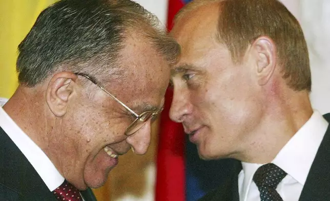 FILE - Russian President Vladimir Putin, right, speaks to his Romanian counterpart Ion Iliescu before a signing ceremony in Moscow, Friday, July 4, 2003.(AP Photo/Ivan Sekretarev, File)