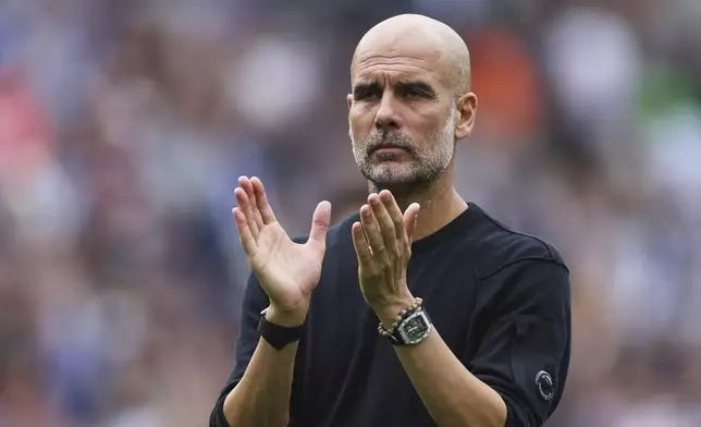Manchester City's head coach Pep Guardiola applauds supporters after the English Premier League soccer match between Brighton and Hove Albion and Manchester City at the Falmer stadium in Brighton, England, Sunday, Aug. 31, 2025. (AP Photo/Ian Walton)