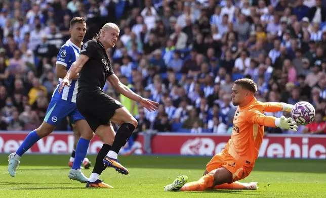 Manchester City's Erling Haaland, second left, scores his side's first goal during the English Premier League soccer match between Brighton and Hove Albion and Manchester City at the Falmer stadium in Brighton, England, Sunday, Aug. 31, 2025. (Adam Davy/PA via AP)