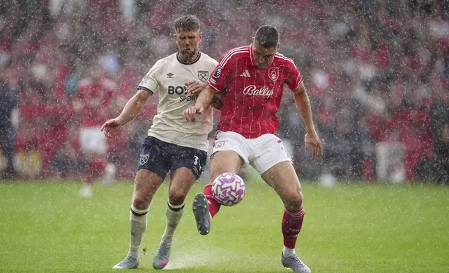 Nottingham Forest's Nikola Milenkovic, right, and West Ham United's Niclas Fullkrug (left) battle for the ball = during the English Premier League soccer match between Nottingham Forest and West Ham United at the City Ground, Nottingham, England, Sunday, Aug. 31, 2025. (Mike Egerton/PA via AP)