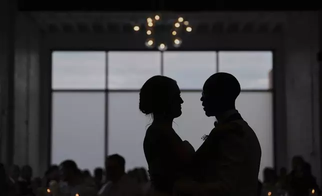 Newlyweds Kayla McDonald, left, and Tyler Jones, right, dance during their wedding reception Saturday, Aug. 23, 2025, in Newtown, Ohio. (AP Photo/Joshua A. Bickel)