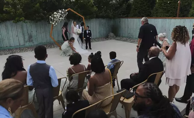 Newlyweds Kayla McDonald and Tyler Jones pose for family photos during their wedding Saturday, Aug. 23, 2025, in Newtown, Ohio. (AP Photo/Joshua A. Bickel)