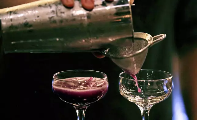FILE - A bartender pours a cocktail in Dec. 10, 2019, in Boston. (AP Photo/Charles Krupa, File)