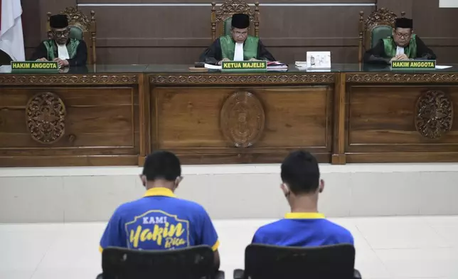 Chief Judge Rokhmadi, center, reads his verdict during the sentencing hearing for two men accused of having gay sex, at the Sharia Court in Banda Aceh, Indonesia, Monday, Aug. 11, 2025. (AP Photo/Reza Saifullah)