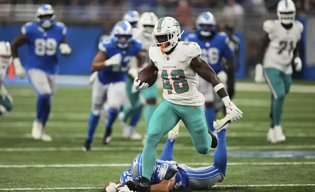 Miami Dolphins running back Jacob Saylors (48) carries against Detroit Lions cornerback Cam Smith (24) during the second half of an NFL preseason football game Saturday, Aug. 16, 2025, in Detroit. (AP Photo/Paul Sancya)