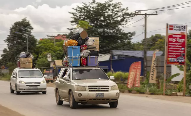 Shuttles packed to the brim with Cambodian migrant workers and their belongings drive away from the Daung International Border Check Point between Cambodia and Thailand, in in Kamrieng, on Wednesday, Aug. 6, 2025. (AP Photo/Anton L. Delgado)