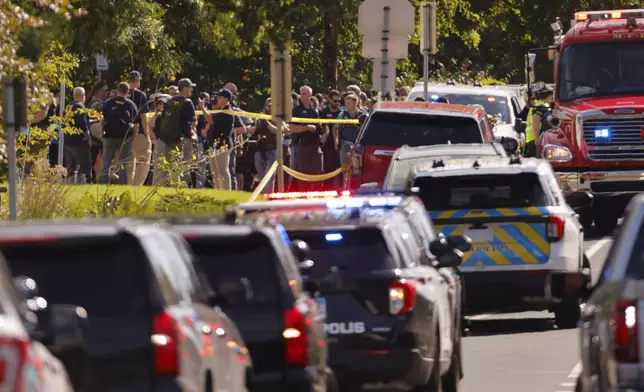 Law enforcement officers gather outside the Annunciation Church's school in response to a reported mass shooting, Wednesday, Aug. 27, 2025, in Minneapolis. (AP Photo/Bruce Kluckhohn)