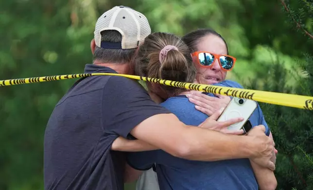 Community members embrace after a shooting at the Annunciation Catholic School on Wednesday, Aug. 27, 2025, in Minneapolis. (Alex Kormann/Star Tribune via AP)