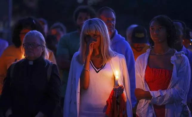 People gather at a vigil at Lynnhurst Park after a shooting at the Annunciation Catholic School Wednesday, Aug. 27, 2025, in Minneapolis. (AP Photo/Bruce Kluckhohn)