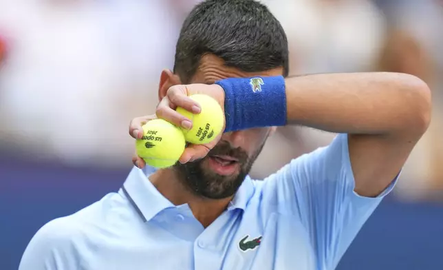 Novak Djokovic, of Serbia, wipes sweat from his face between serves to Zachary Svajda, of the United States, during the second round of the U.S. Open tennis championships, Wednesday, Aug. 27, 2025, in New York. (AP Photo/Kirsty Wigglesworth)