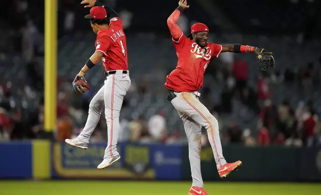 Cincinnati Reds' Santiago Espinal, left, and Elly De La Cruz celebrate after the Reds defeated the Los Angeles Angels 6-4 in a baseball game Tuesday, Aug. 19, 2025, in Anaheim, Calif. (AP Photo/Mark J. Terrill)