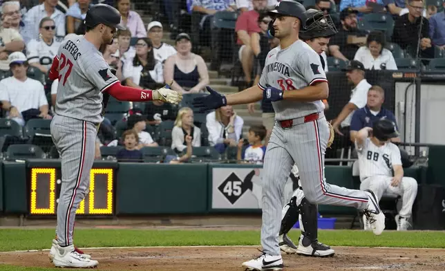 Minnesota Twins' Matt Wallner, right, is greeted by Ryan Jeffers, left, after hitting a home run against the Chicago White Sox during the fourth inning of a baseball game Saturday, August 23, 2025, in Chicago. (AP Photo/David Banks)