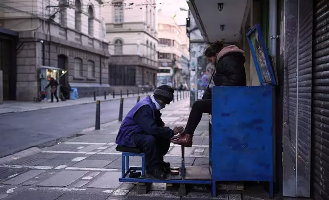 A show shiner works on a client's shoes in La Paz, Bolivia, Wednesday morning, Aug. 13, 2025. (AP Photo/Natacha Pisarenko)