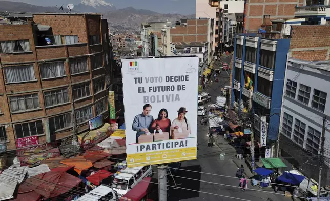 A Tribunal Electoral billboard with a message that reads in Spanish; "Your vote decides the future of Bolivia, participate" towers over a street in La Paz, Bolivia, Friday, Aug. 15, 2025, ahead of the country's upcoming general election. (AP Photo/Victor R. Caivano)