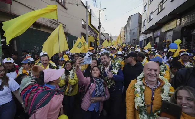 Bolivian presidential candidate Samuel Doria Medina poses for a selfie with a supporter while campaigning five days before presidential elections, in La Paz, Bolivia, Tuesday, Aug. 12, 2025. (AP Photo/Natacha Pisarenko)