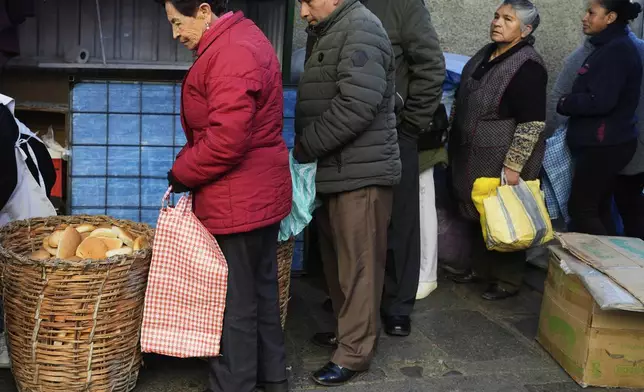 People line up to buy "pan de batalla," or battle bread, made with government subsidized flour, in La Paz, Bolivia, Saturday, Aug. 9, 2025. (AP Photo/Juan Karita)