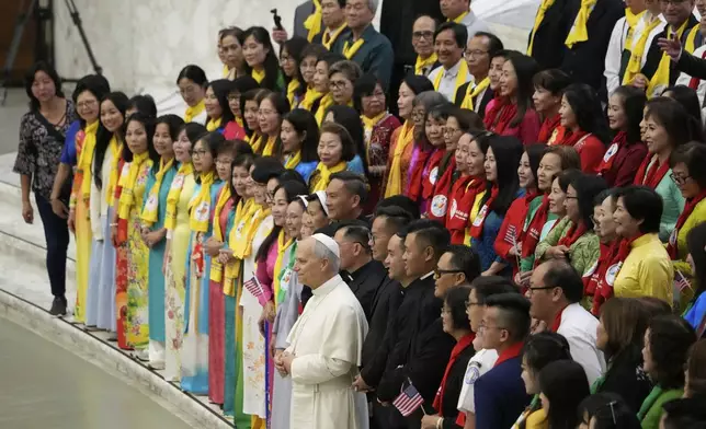 Pope Leo XIV, front center, poses with Vietnamese faithful during the weekly general audience at the Vatican, Wednesday, Aug. 27, 2025. (AP Photo/Gregorio Borgia)