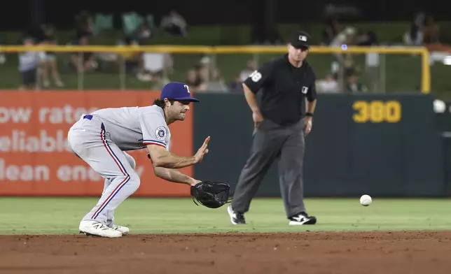 Texas Rangers shortstop Josh Smith fields the ball during the eighth inning of a baseball game against the Athletics, Friday, Aug. 29, 2025, in West Sacramento, Calif. (AP Photo/Sara Nevis)