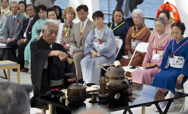 FILE - Genshitsu Sen XV, grand tea master of the Urasenke School of Tea, performs a traditional Japanese Tea Ceremony on the USS Arizona Memorial at Pearl Harbor, July 19, 2011, in Honolulu. Pearl Harbor survivors along with honored guest participated in the morning ceremony. The tea ceremony honors Americans who lost their lives when Japan attacked Pearl Harbor Dec. 7, 1941. (AP Photo/Eugene Tanner, File)