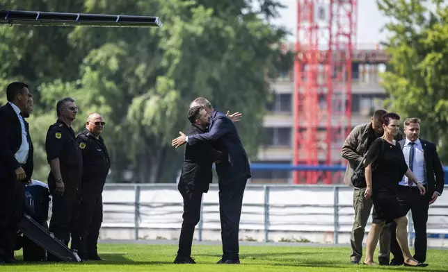 Ukrainian President Volodymyr Zelenskyy, center left, is welcomed by German Chancellor Friedrich Merz upon arrival in the garden of the chancellery in Berlin, Germany, Wednesday, Aug. 13, 2025 to join a video conference of European leaders with the U.S. President on the Ukraine war. (John MacDougall/Pool Photo via AP)