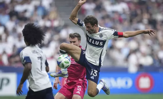Vancouver Whitecaps Thomas Muller (13) and St. Louis City's Henry Kessler (5) vie for the ball during the first half of an MLS soccer match, in Vancouver, on Saturday, August 23, 2025. (Darryl Dyck/The Canadian Press via AP)