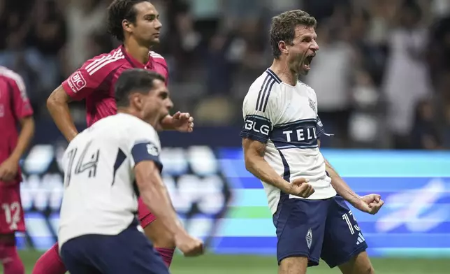 Vancouver Whitecaps Thomas Muller, right, celebrates his winning penalty kick goal against St. Louis City during the second half of an MLS soccer match, in Vancouver, British Columbia, Saturday, Aug. 23, 2025. (Darryl Dyck/The Canadian Press via AP)
