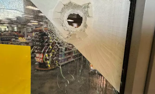 A bullet hole is visible in the door of a CVS pharmacy on Saturday, August 9, 2025, near where police say a man was shooting at the headquarters of the U.S. Centers for Disease Control and Prevention in Atlanta (AP Photo/Jeff Amy)