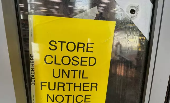 A bullet hole is visible in the door of a CVS pharmacy on Saturday, August 9, 2025, near where police say a man was shooting at the headquarters of the U.S. Centers for Disease Control and Prevention in Atlanta (AP Photo/Jeff Amy)