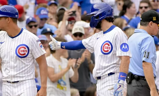 Chicago Cubs' Dansby Swanson, front right, celebrates after his RBI triple against the Pittsburgh Pirates during the fifth inning of a baseball game, Sunday, Aug. 17, 2025, at Wrigley Field in Chicago. (AP Photo/Mark Black)