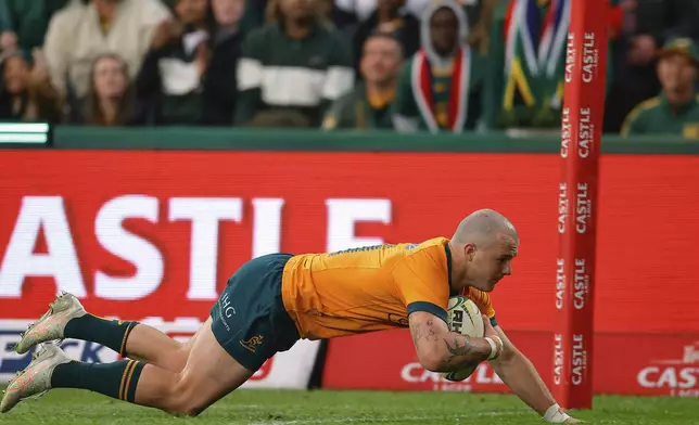 Australia's Dylan Pietsch dives over the line to score a try during a rugby championship test match between South Africa and Australia, at Ellis Park stadium in Johannesburg, South Africa, Saturday, Aug. 16, 2025. (AP Photo/Frans Lombard)