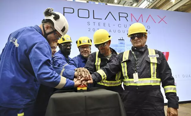Davie's and Helsinki Shipyard's staff members pose for a group photo during a steel cutting ceremony for the beginning of construction of the Polar Max Icebreaker in Helsinki Shipyard in Helsinki, Finland, Wednesday, Aug. 20, 2025. (Markku Ulander/Lehtikuva via AP)