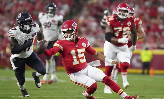 Kansas City Chiefs quarterback Patrick Mahomes (15) scrambles as Chicago Bears linebacker Ruben Hyppolite II (47) defends during the first half of a preseason NFL football game Friday, Aug. 22, 2025, in Kansas City, Mo. (AP Photo/Ed Zurga)