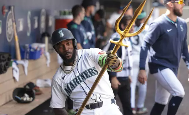 Seattle Mariners' Randy Arozarena celebrates in the dugout after hitting a two-run home run off Chicago White Sox starting pitcher Shane Smith during the third inning of a baseball game, Thursday, Aug. 7, 2025, in Seattle. (AP Photo/Jason Redmond)