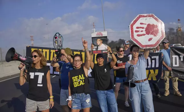 Activists block a highway during a protest demanding the immediate release of hostages held by Hamas and calling for the Israeli government to reverse its decision to take over Gaza City and other areas in the Gaza Strip, near the city of Lod, Israel, Tuesday, Aug. 26, 2025. (AP Photo/Ohad Zwigenberg)