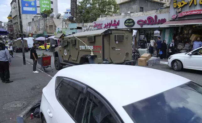 Israeli army vehicles raid currency exchange companies in the West Bank city of Ramallah, Tuesday, Aug. 26, 2025. (AP Photo/Nasser Nasser)