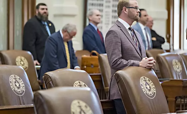 Texas House Rep. Daniel Alders, R - Tyler, stands at his desk during with empty chairs belonging to House Democrats remain empty in the State Capitol, Tuesday, Aug. 5, 2025, in Austin, Texas. (AP Photo/Rodolfo Gonzalez)