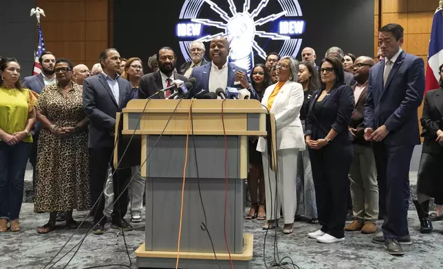 Democratic Texas Rep. Ron Reynolds, center, surrounded by other Texas House Democrats and Democratic members of Congress, speaks during a press conference at the Democratic Party in Warrenville, Ill., Monday, Aug. 4, 2025. (AP Photo/Nam Y. Huh)