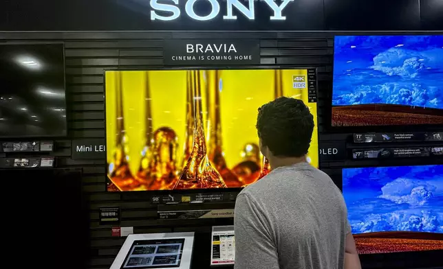 A man views a new television at a store in Kennesaw, Ga., on Thursday, Aug. 14, 2025. (AP Photo/Mike Stewart)