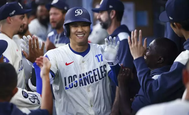 Los Angeles Dodgers' Shohei Ohtani celebrates in the dugout with his teammates after hitting a home run during the fifth inning of a baseball game against the Toronto Blue Jays, Saturday, Aug. 9, 2025, in Los Angeles. (AP Photo/Jessie Alcheh)