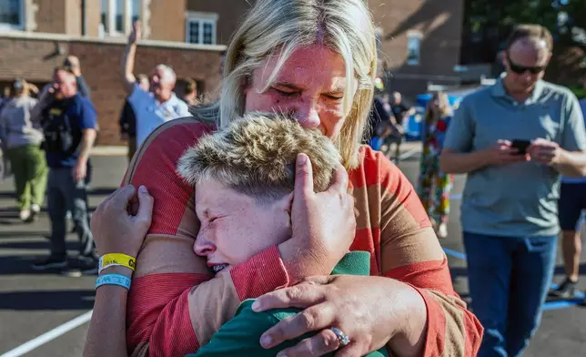 A parent hugs her son during an active shooter situation at the Annunciation Church in Minneapolis, Minn., Wednesday, Aug. 27, 2025. (Richard Tsong-Taatarii/Star Tribune via AP)