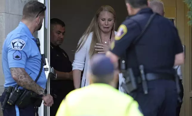 A person walks out of the Annunciation Church's school as police response to a reported mass shooting, Wednesday, Aug. 27, 2025, in Minneapolis. (AP Photo/Abbie Parr)