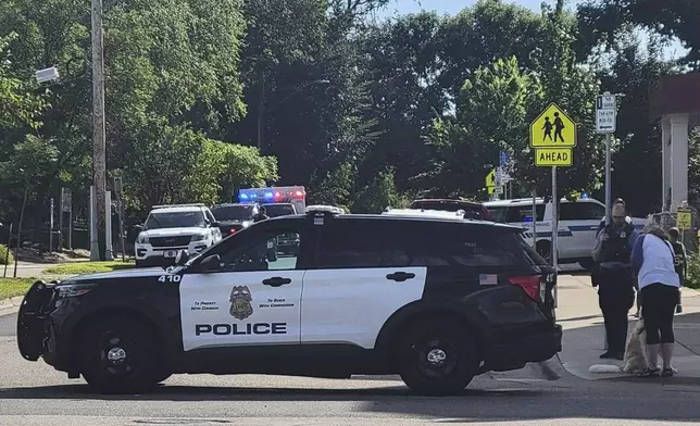 Law enforcement officers gather outside the Annunciation Church's school in response to a reported mass shooting, Wednesday, Aug. 27, 2025, in Minneapolis. (AP Photo/Bruce Kluckhohn)