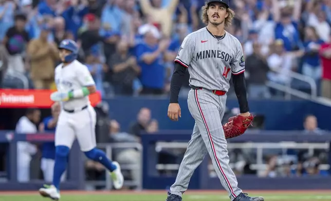 Minnesota Twins starting pitcher Joe Ryan, right, reacts as Toronto Blue Jays' Bo Bichette rounds the bases on Blue Jays' Alejandro Kirk's two-run home run in first-inning baseball game action in Toronto, Monday, Aug. 25, 2025. (Frank Gunn/The Canadian Press via AP)