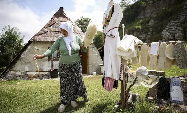 A Bosnian Muslim woman prepares wool that she later knits into sweaters or socks and sells to tourists in Umoljani village on Bjelasnica mountain near Sarajevo, Bosnia, Tuesday, Aug. 5, 2025. (AP Photo/Armin Durgut)