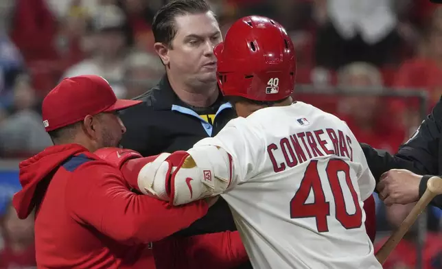 St. Louis Cardinals' Willson Contreras (40) is held back by Cardinals manager Oliver Marmol, left, after being ejected by home plate umpire Derek Thomas, center, during the seventh inning of a baseball game against the Pittsburgh Pirates Monday, Aug. 25, 2025, in St. Louis. (AP Photo/Jeff Roberson)