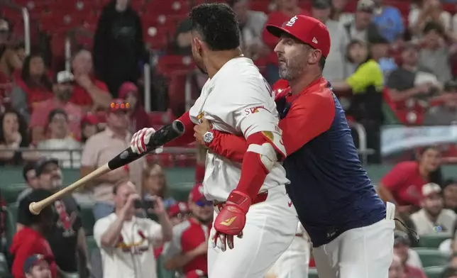 St. Louis Cardinals' Willson Contreras, left, is held back by Cardinals bench coach Daniel Descalso after being ejected during the seventh inning of a baseball game against the Pittsburgh Pirates Monday, Aug. 25, 2025, in St. Louis. (AP Photo/Jeff Roberson)